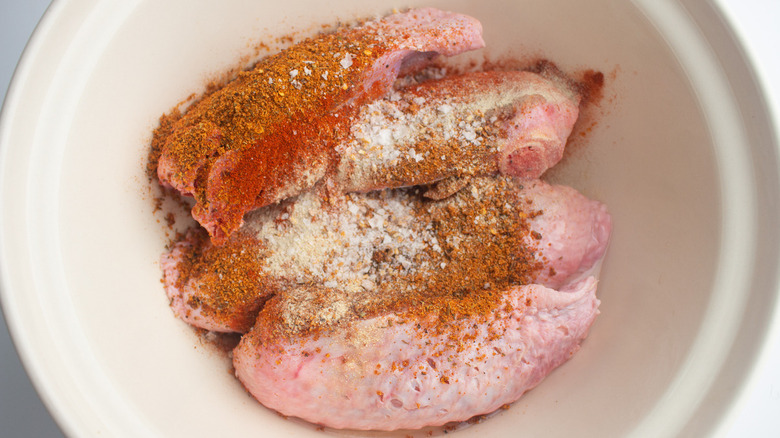 Turkey wings with seasoning in a bowl