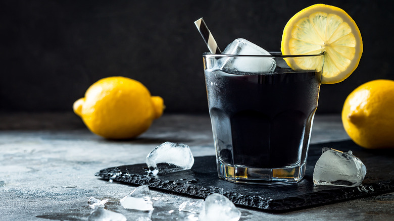 black cocktail with lemon