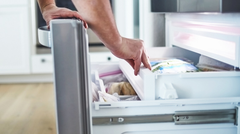 man opening freezer drawer