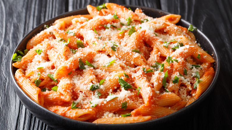 pasta with sauce and cheese in black bowl