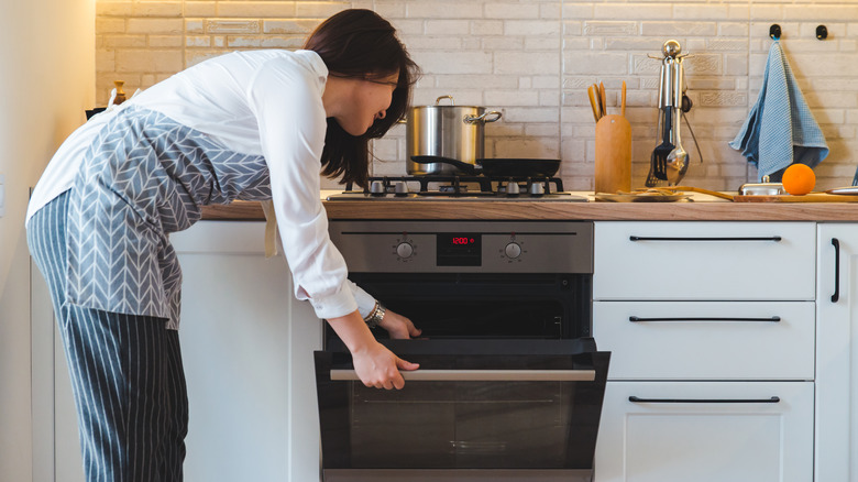 Woman opening oven