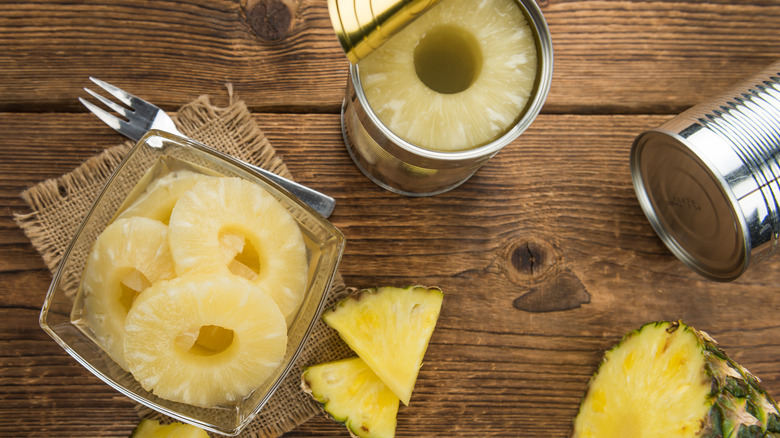 Sliced pineapple on plate and in cans