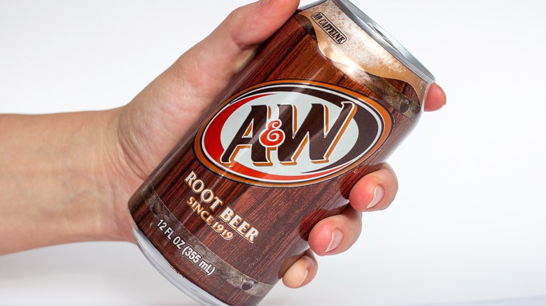 Hand holding A&W root beer can