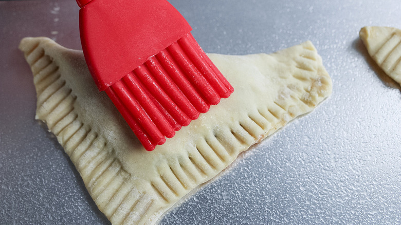 Brushing turnovers with egg wash