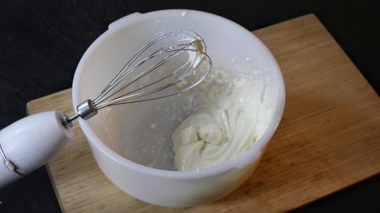 whisk on bowl of cream cheese glaze