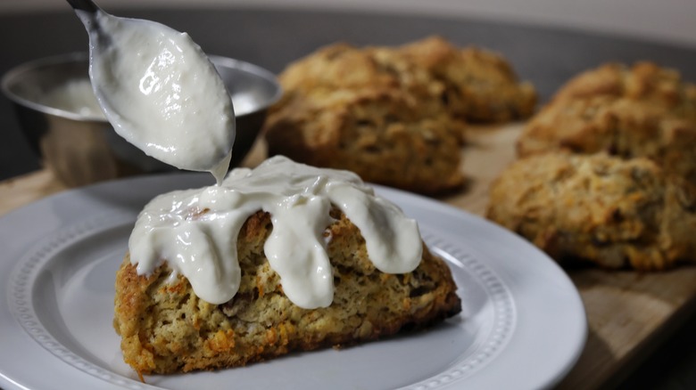 spooning glaze on carrot cake scone