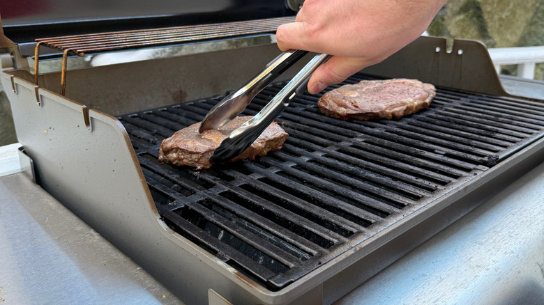 steaks cooking on grill