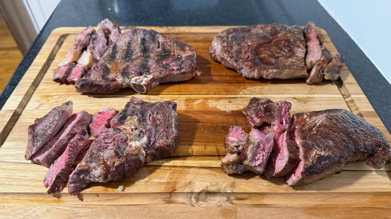 four steaks on cutting board