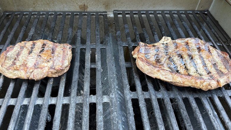 two steaks on a grill