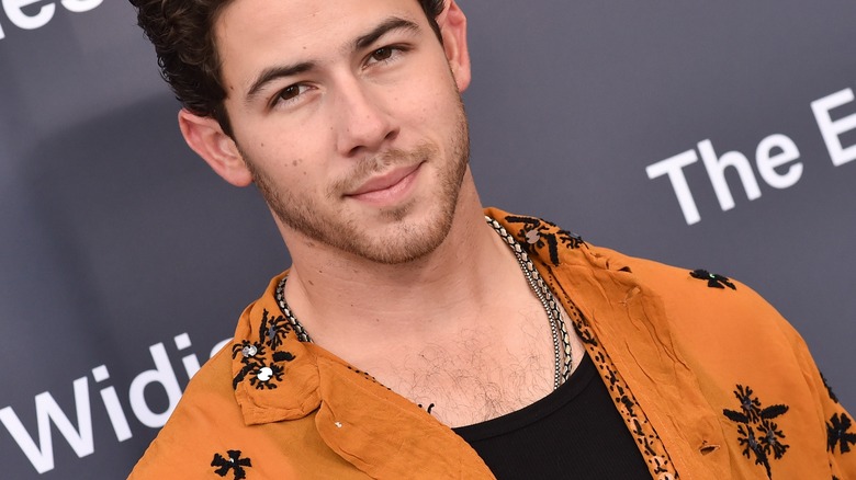 Nick Jonas in orange shirt