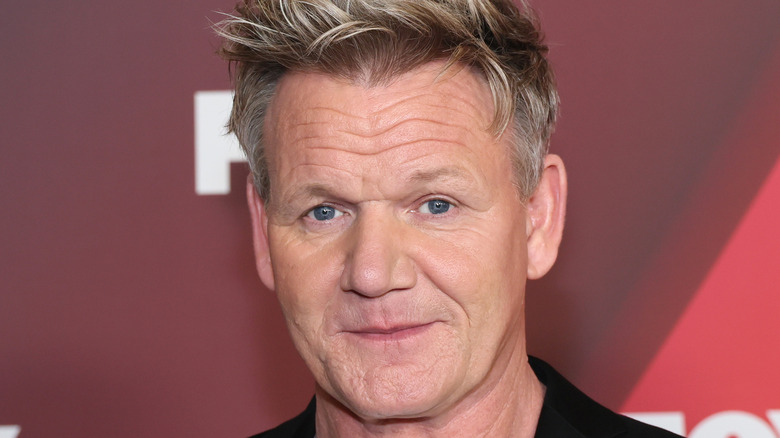 Gordon Ramsay poses with red background