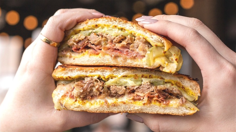 hands holding Cuban sandwich