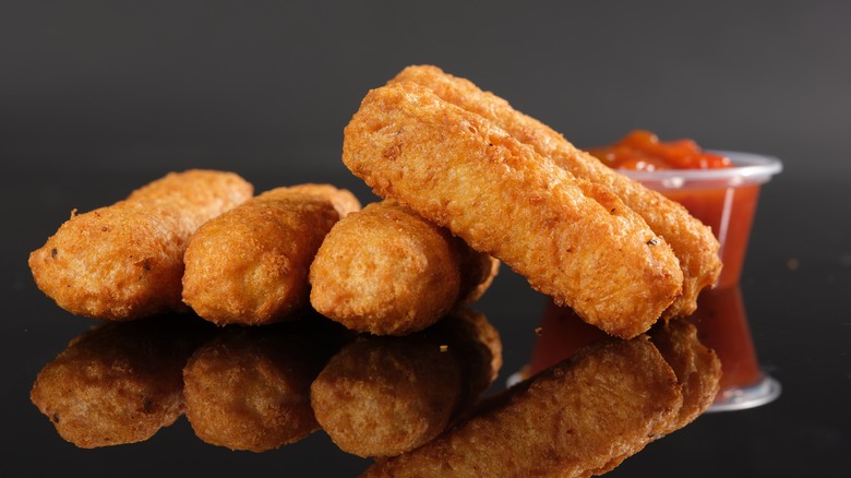 Mozzarella sticks with sauce in the background