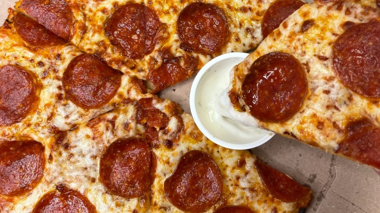 Domino's pepperoni pizza dipping into ranch