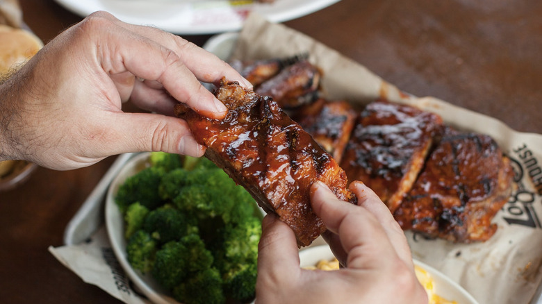 Man eating Logan's Roadhouse ribs