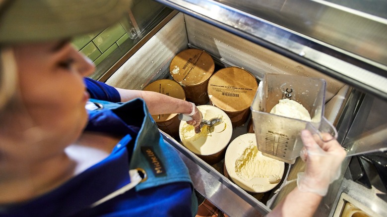 Employee scooping ice cream
