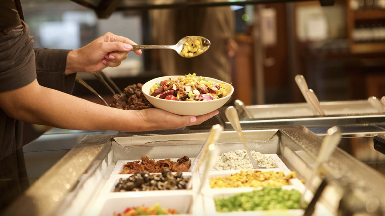 person filling bowl Sizzler buffet