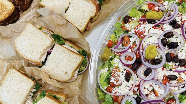 Panera Sandwiches arranged in a line next to a salad covered in toppings