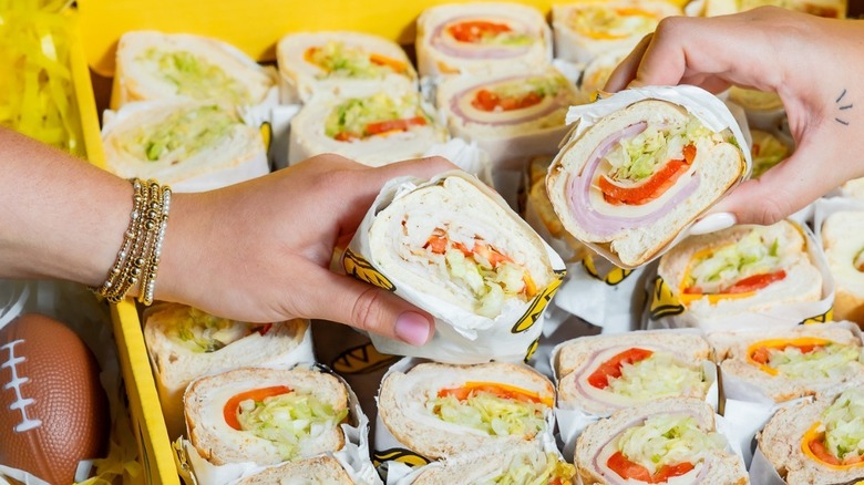 People reaching for Which Wich subs in yellow box