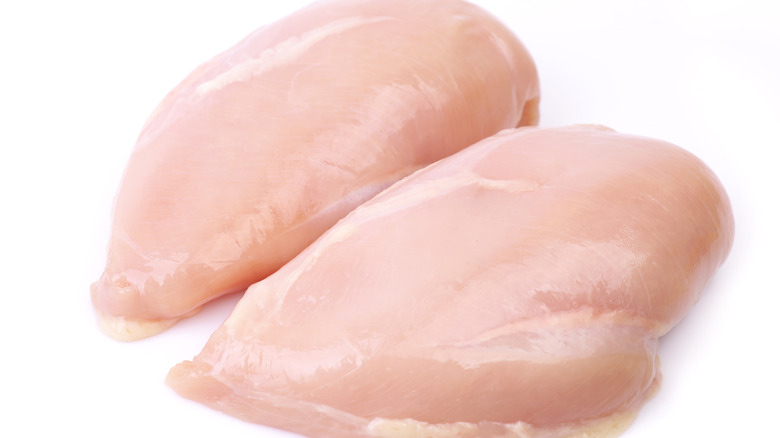 two raw boneless skinless chicken breast pieces