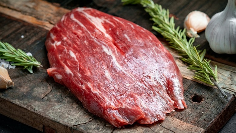 Raw flank steak with rosemary