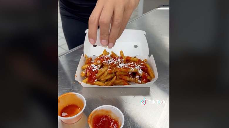 Hand sprinkling sugar on fries