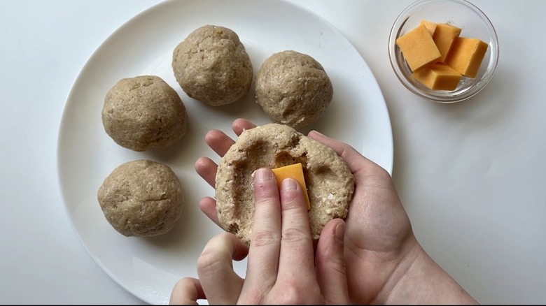 hand putting cheese on meat