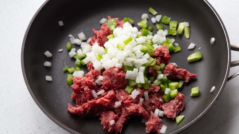 ground beef, onion, and peppers in a skillet