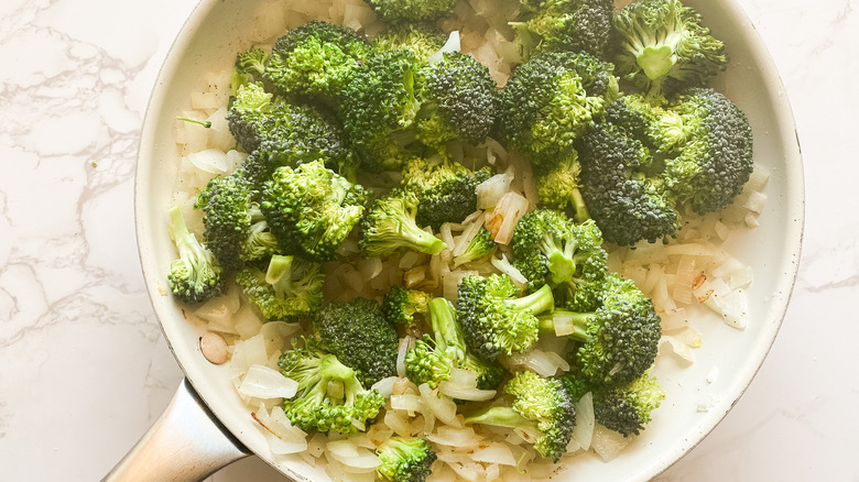 A pan with onions and broccoli