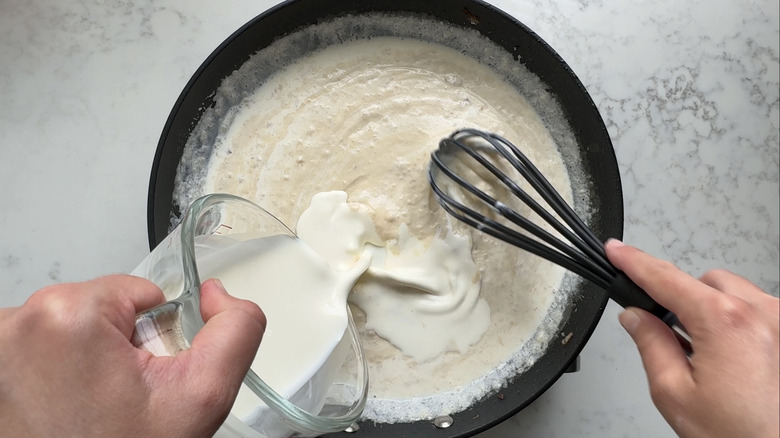 hand pouring liquid into pan