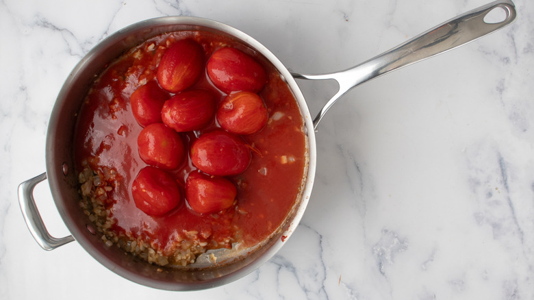 whole canned tomatoes in a frying pan