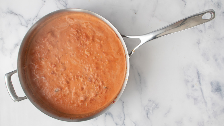 pinkish-orange sauce in a frying pan