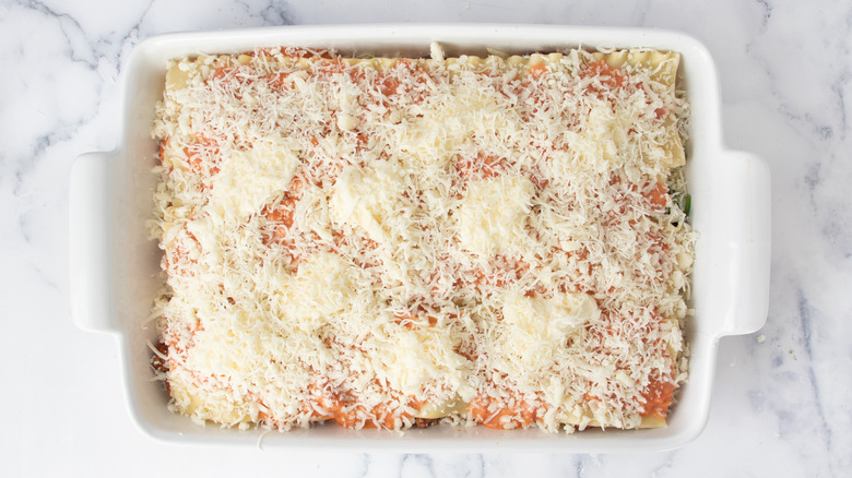 uncooked lasagna in a white pan