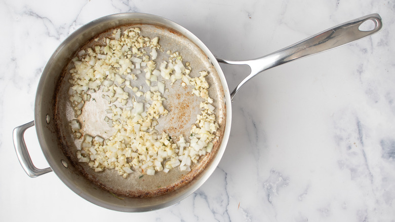 chopped onions and garlic in a frying pan