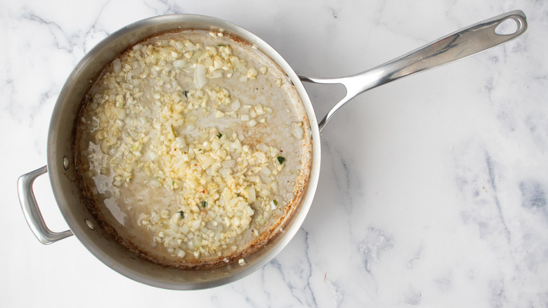 chopped onions and garlic in a frying pan