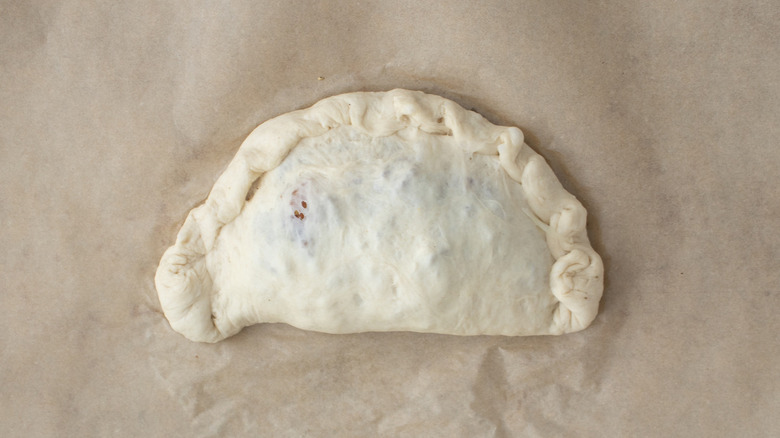 unbaked calzone on brown paper