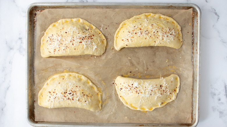 unbaked calzones on brown paper