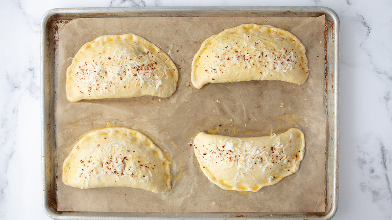 unbaked calzones on brown paper