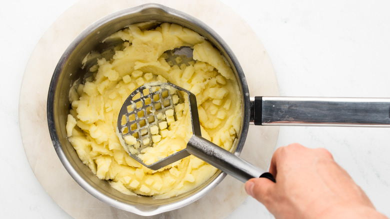 mashing potatoes in pan