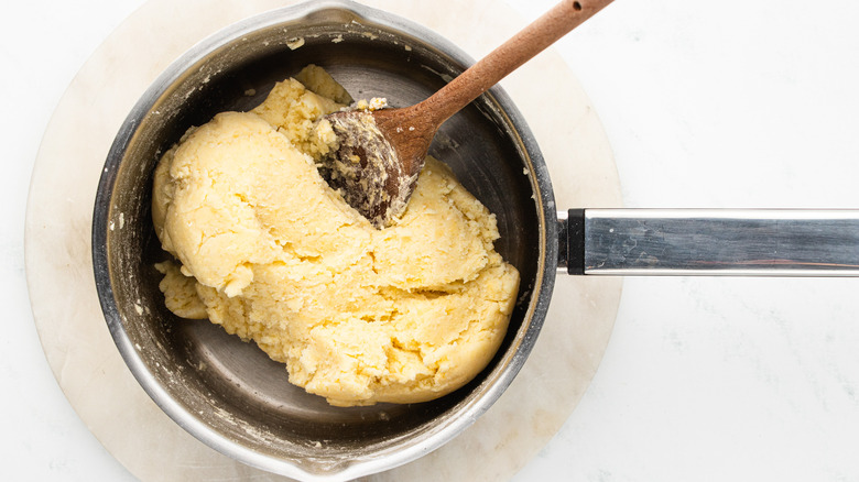 mixing gnocchi dough in saucepan