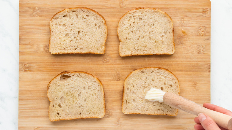 Bread being brushed with oil