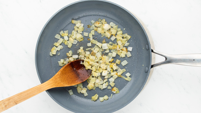 onion and garlic sauteing in frying pan