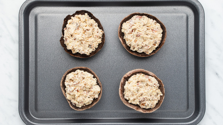 stuffed mushrooms on baking sheet