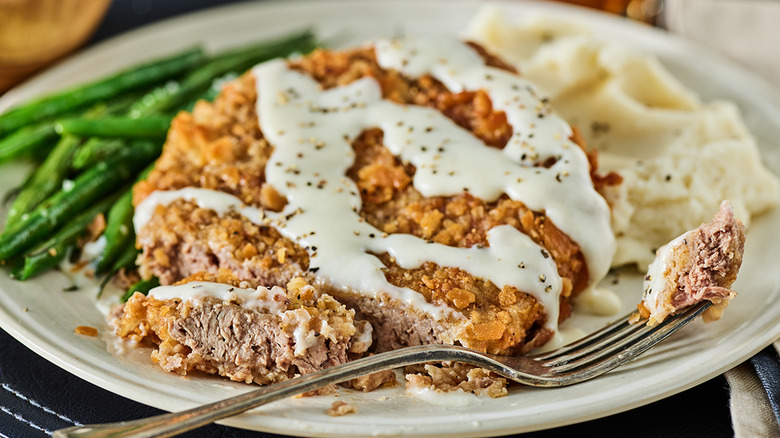 Sliced open chicken fried steak with gravy