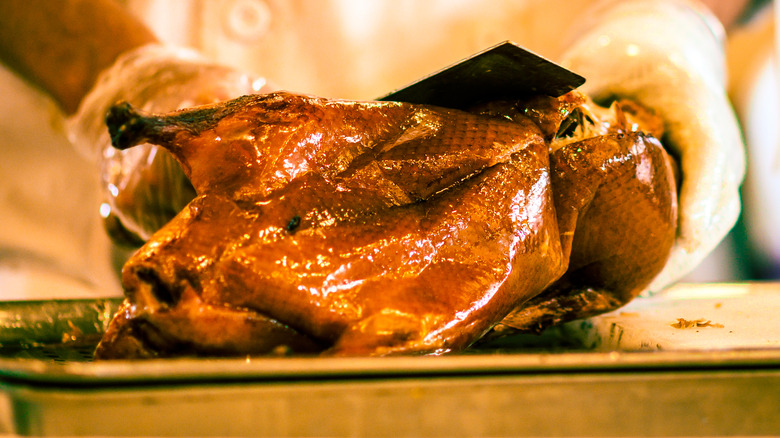 A Peking duck getting carved