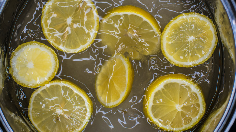 halved lemons in boiling liquid