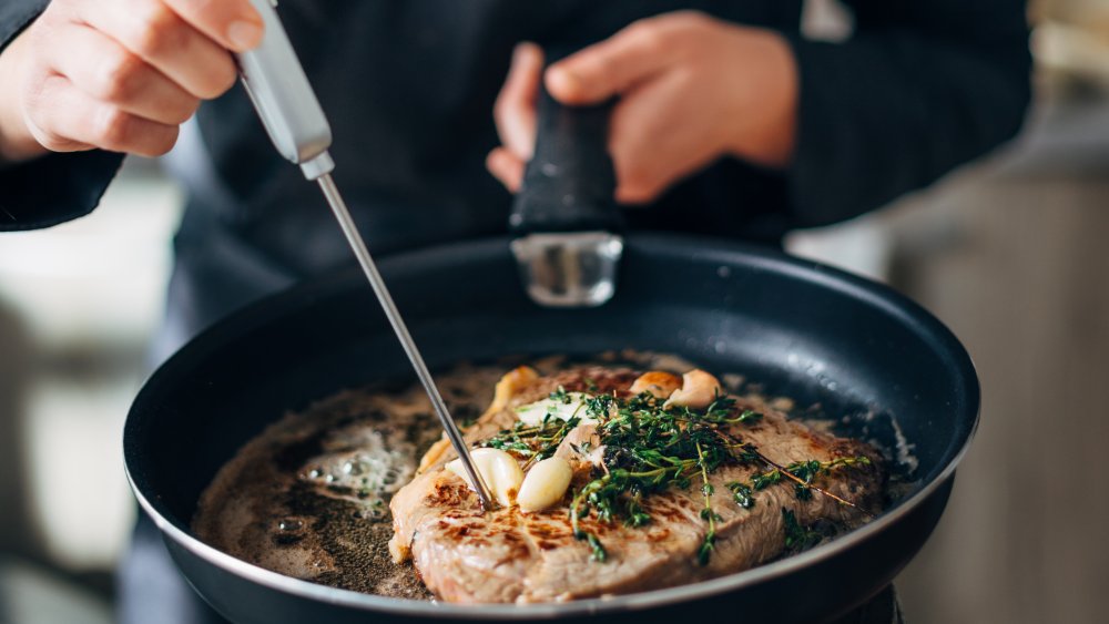 Using meat thermometer to check steak temperature