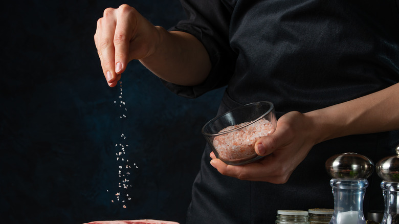 A chef salting meat