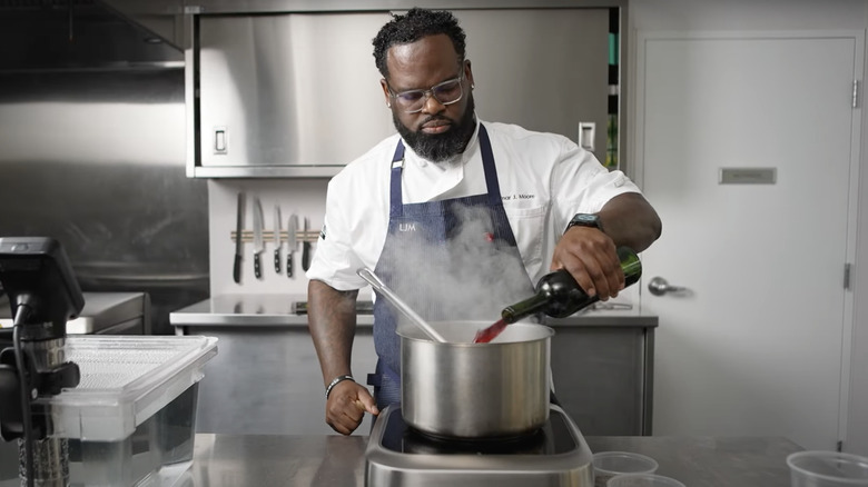 Lamar Moore pouring wine into a pot