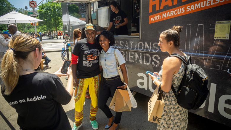 Chef Marcus Samuelsson with fan in front of food truck